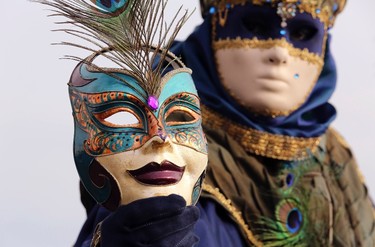 A masked reveller poses in front of St. Mark's square during the first day of carnival in Venice February 1, 2015. REUTERS/Stefano Rellandini