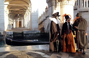Masked revellers pose near a canal next to St. Mark's square during the first day of carnival, in Venice February 1, 2015. REUTERS/Stefano Rellandini