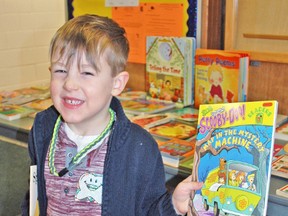 Beckett Gloor proudly displays his new book during Literacy Day events at Upper Thames Elementary School in Mitchell last Tuesday, Jan. 27. Approximately 1,100 books were part of the community book exchange, which also saw entertainment and other activities at the school. KRISTINE JEAN/MITCHELL ADVOCATE