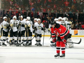 Jon Merrill #7 of the New Jersey Devils skates off as the Pittsburgh Penguins celebrate their overtime win at the Prudential Center on January 30, 2015 in Newark, New Jersey.  (Adam Hunger/Getty Images/AFP)
