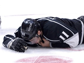 Los Angeles Kings center Anze Kopitar holds his throat as he lays on the ice in the third period of the game against the Toronto Maple Leafs at Staples Center on Jan. 12, 2015. (Jayne Kamin-Oncea/USA TODAY Sports)