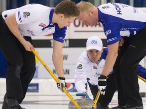 Skip Mark Kean releases a rock as second David Mathers (left) and lead Scott Howard sweep during the Ontario Takard. (CRAIG GLOVER/QMI AGENCY)
