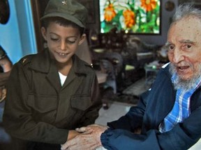 Picture belonging to the Mendez's family of Cuban former president Fidel Castro (R) holding Marlon Mendez's hand during his visit to Castro's house on August 16, 2014 in Havana.     AFP PHOTO / ARCHIVO FAMILIAR