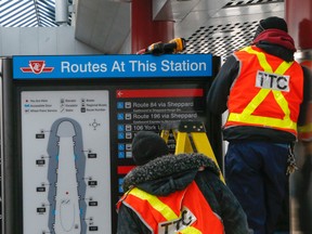 TTC employees work to remove the controversial sign at Downsview station. (DAVE THOMAS/Toronto Sun)