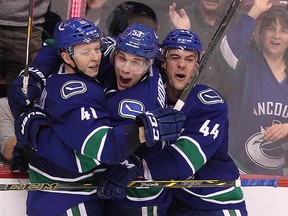 Vancouver Canucks forward Ronalds Kenins (41) celebrates his third period goal with teammates Bo Horvat (centre) and Adam Clendening (44)  during Vancouver's 3-2 victory over the Winnipeg Jets in NHL action at Rogers Arena in Vancouver, B.C. on Tuesday February 3, 2015. Carmine Marinelli/QMI Agency