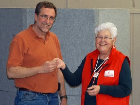 Elsie Stratton of Canadian Blood Services gives a pin to Wallaceburg's Randy VanDorsselaer as he gives his 150th donation on Jan. 22 at the UAW Hall
