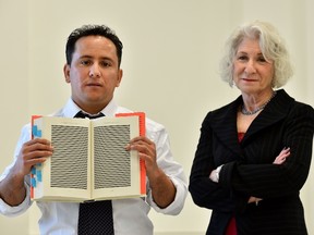 The younger brother of Mohamedou Ould Slahi, Yahdih Ould Slahi (L) and US attorney Nancy Hollander (R) poses with a copy of Yahdih's prison memoir 'Guantanamo Diary' open to show pages that were redacted by the US government in London on January 20, 2015. The family and supporters of "one of the most abused prisoners in Guantanamo" on January 20 launched a new celebrity-backed campaign demanding his release, coinciding with the publication of his prison diary. Yahdih Ould Slahi was detained in his home country of Mauritania following the September 11 attacks on the United States in 2001, on suspicion of involvement in an unsuccessful plot to bomb Los Angeles in 1999, and was taken to Guantanamo in 2002. US district court judge James Robertson ordered that Slahi be released in 2010 due to lack of evidence that he was directly involved in al-Qaeda terror plots, but he remains in detention after the Department of Justice appealed the decision. Human rights activist Larry Siems, the book's editor, Slahi's lawyer Nancy Hollander and brother Yahdih described the battle to release the memoirs and his current legal limbo during a press conference in London. AFP PHOTO / BEN STANSALL