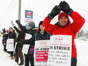 Health-care workers wave to motorists as they picket in Peterborough on Wednesday, Feb. 4, 2015. (Clifford Skarstedt/Peterborough Examiner/QMI Agency)