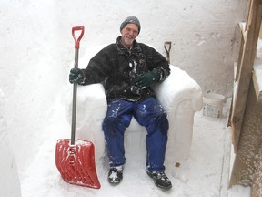 Peter Vogelaar sits on a snowy chair inside the ice maze in Confederation Park, built for the opening of FebFest on Thursday. (Michael Lea/The Whig-Standard)