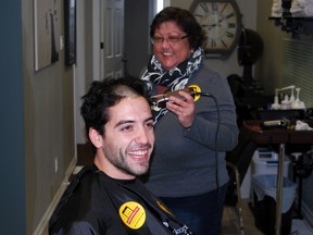 Ivana Brisson, right, helps shave the head of her son Adam at Crown of Jewels Salon in St. Thomas on Wednesday, World Cancer Day. Adam had his head shaved in honour of Ivana, who has non-Hodgkin's lymphoma. He raised over $2,500 for cancer research in just six days. (Ben Forrest/Times-Journal)