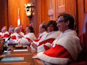 Newly-appointed Supreme Court of Canada Justice Clement Gascon (R) shares a laugh with fellow justices during a welcoming ceremony at the Supreme Court of Canada in Ottawa October 6, 2014. REUTERS/Chris Wattie