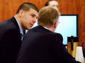 Former New England Patriots football player Aaron Hernandez is seen communicating with his defence attorney, Charles Rankin, during the fifth day of the trial in Fall River, Massachusetts, February 5, 2015. (REUTERS/Faith Ninivaggi/Pool)