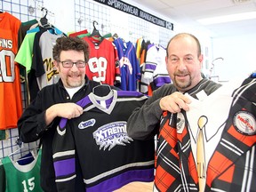 Mark (left) and Yale Singer, co-owners of Harv-Al Sportswear, display some of their jerseys in their business Thursday Feb. 5, 2015.