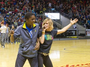 Kensal Park French Immersion grade 7 pupil Justin Tham bumps hips with motivational singer Sara Westbrook as she performs for nearly 8,000 elementary school kids from across the Thames Valley District School Board during Be A Champ Day at Budweiser Gardens in London, Ontario on Thursday February 5, 2015.  
CRAIG GLOVER/The London Free Press