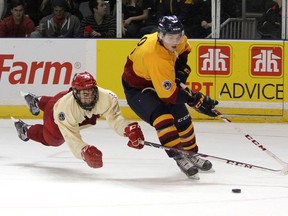 Queen's Golden Gaels Braeden Corbeth gets past Royal Military College Paladins’ Deric Boudreau during the 29th annual Carr-Harris Cup hockey game at the Rogers K-Rock Centre on Thursday night. The Gaels won 5-1. (Ian MacAlpine/The Whig-Standard)