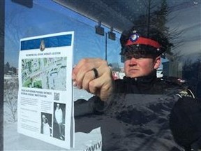 A York Regional Police officer puts up posters about a violent sex attack in Richmond Hill. (DAVE THOMAS/Toronto Sun)