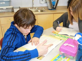 St. Matthew's Catholic School students Luc Lacroix and Alyson Burns pore over their workbooks during Junior Achievement's Dollars with Sense program.
CARL HNATYSHYN/SARNIA THIS WEEK/QMI AGENCY