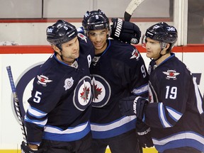 Winnipeg Jets left winger Evander Kane (c) is congratulated by teammates defenceman Mark Stuart (l) and center Jim Slater after scoring an empty net goal in the Jets' 4-2 victory over the New Jersey Devils Dec. 3, 2011.