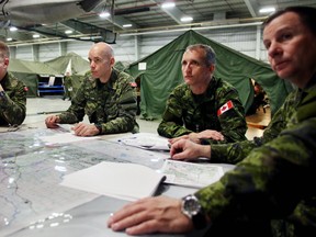 Canadian Armed Forces Brig.-Gen Wayne Eyre, Commander of 3rd Canadian Division and Joint Task Force West, second from left, and 1 Canadian Mechanized Brigade Group (1 CMBG) commander Trevor Cadieu, right receive a briefing during Exercise SENECA RAM  at CFB Edmonton on Tuesday, February 3, 2015  in Edmonton, AB. TREVOR ROBB/EDMONTON SUN/QMI AGENCY