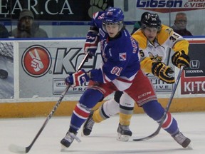 Kitchener Rangers defenceman Dmitrii Sergeev protects the puck from Sarnia Sting forward Nikita Korostelev during the Ontario Hockey League game in Kitchener on Friday night. Kitchener collected a one-goal victory to split the home-and-home series. (TERRY BRIDGE, The Observer)