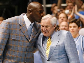 Former University of North Carolina player and NBA standout Michael Jordan kisses former University of North Carolina head coach Dean Smith during a ceremony honoring the 1957 and 1982 national championship teams at halftime of the NCAA basketball game between North Carolina and Wake Forest University. REUTERS/Ellen Ozier/Files