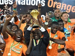 Guillaume Soro, (C) president of the Ivorian parliament, raises the trophy at the end of the 2015 African Cup of Nations final football match between Ivory Coast and Ghana in Bata on February 8, 2015. (AFP PHOTO / ISSOUF SANOGO)