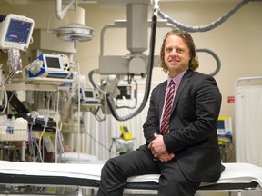 Dr. Adam Dukelow sits on a bed in the resuscitation and trauma room at Victoria Hospital's emergency department in London, Ontario. (CRAIG GLOVER, The London Free Press)