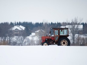 A tractor sits in a snow-covered field on Hamilton Road east of London, Ontario on Sunday February 8, 2015. (CRAIG GLOVER, The London Free Press)