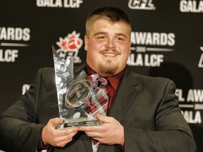Calgary Stampeders Brett Jones, holds his trophy after winning the Most Outstanding Offensive Lineman award at the annual CFL player awards ahead of the 102nd Grey Cup in Vancouver, BC on Thursday November 27, 2014. (Al Charest/Calgary Sun/QMI Agency)