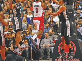 Raptors forward James Johnson goes to the basket between two Spurs Sunday night at the ACC. (JACK BOLAND/Toronto Sun)
