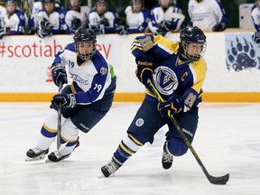 Julie Hebert, right, of the Laurentian Voyageurs, eludes Blair Malthaner, of the Ryerson Rams, during OUA Women's hockey action at the Gerry McCrory Countryside Sports Complex in Sudbury on Saturday. OHN LAPPA/THE SUDBURY STAR/QMI AGENCY