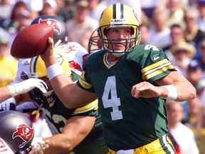 In this September 13, 1998 file photo, quarterback Brett Favre of the Green Bay Packers throws under pressure against the Tampa Bay Buccaneers during the first half of their game at Lambeau Field, in Green Bay, Wisconsin.  Favre, the National Football League's all-time passing leader, said February 9, 2015 he will return to Green Bay later this year to have his number four jersey retired by the Packers. The 45-year-old, a three-time NFL Most Valuable Player who spent 16 of his 20 NFL seasons with the Packers, made the announcement on his website. AFP PHOTO/Jeff HAYNES / FILES