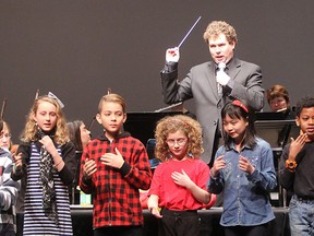 Kingston Symphony music director Evan Mitchell conducts the orchestra behind him as students from Sydenham Public School perform Ode to Joy in American Sign Language during a Symphony Education Partnership concert Monday morning at The Grand Theatre. (Michael Lea/The Whig-Standard)