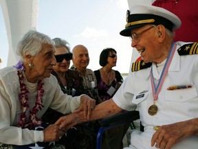 Joann Olsen (L) shares a light-hearted moment with USS Arizona survivor Joseph Langdell (R) after the internment ceremony of her husband, USS Arizona survivor Vernon J. Olsen, aboard the USS Arizona Memorial during the 70th anniversary of the attack on Pearl Harbor at the World War II Valor in the Pacific National Monument in Honolulu, Hawaii December 7, 2011. REUTERS/Hugh Gentry