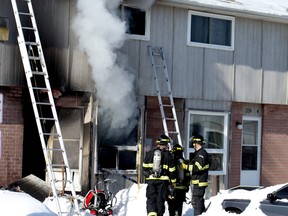 Woodstock firefighters gather in front of a Springbank Gardens townhouse off of Springbank Ave. and Devonshire Ave., where a fire completely destroyed the inside of the residence. (BRUCE CHESSELL/Sentinel-Review file photo)