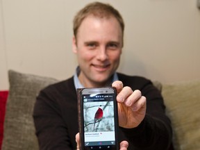 Josh Janvrin poses with his phone showing the App he created called Check Chirp which contains a list of local Cochrane birds to help bird sighting documentation easier in our area. The free app can be found in the Google Play store.