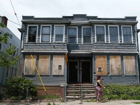 A woman passes by an empty house in Newark, New Jersey in this May 13, 2014 file photo. (REUTERS/Eduardo Munoz)