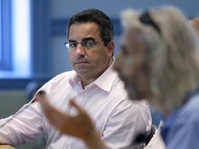 City of Ottawa Deputy City Manager, Community & Protective Services, Steve Kanellakos (L) listens to a member of the public speak to a committee regarding some of the social services that are in jeopardy because of a potential funding shortfall.