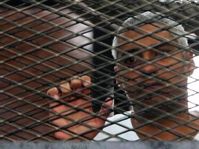 Canadian-Egyptian journalist Mohamed Fahmy stands behind bars at a court in Cairo, May 15, 2014. (Reuters/Stringer)