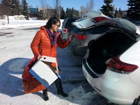 Former Plasco employee Xiao-Mei Shi puts her belongings in her trunk as she leaves the company's headquarters in Kanata after finding out she was one of 80 employees laid off on Tuesday. (Doug Hempstead/Ottawa Sun)