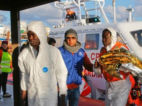 Migrants who survived a shipwreck are escorted as they arrive at the Lampedusa harbour February 11, 2015. An Italian tug boat rescued 9 people who had been on two different boats on Monday and brought them to the Italian island of Lampedusa on Wednesday morning. 
They are the only known survivors from their two boats, leaving more than 200 unaccounted for, they told representatives of the United Nations High Commissioner for Refugees (UNHCR). REUTERS/Antonio Parrinello