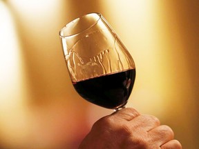 Remi Edange, manager at Domaine de Chevalier, inspects a glass of red wine in the cellar of Chateau Domaine de Chevalier February 10, 2015. (REUTERS/Regis Duvignau)