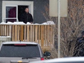 Police talk to a man in a house they had surrounded near 99 Street and 68 Avenue, in Edmonton Alta., on Wednesday Feb. 11, 2015. Police were responding to a call about a man with a machete. David Bloom/Edmonton Sun