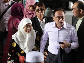 Malaysia's opposition leader Anwar Ibrahim (2nd R) arrives with his wife Wan Azizah (L), for the verdict in his final appeal against a conviction for sodomy, at the federal court in Putrajaya, February 10, 2015. Malaysia's highest court rejected on Tuesday Anwar's appeal against a 2014 sodomy conviction and upheld a five-year prison term that will likely end a political career marked by controversy.      REUTERS/Stringer