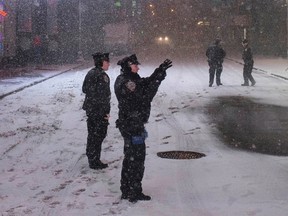 A New York Police Department officer takes photographs while keeping security during a snowstorm in Times Square, New York early morning January 27, 2015. (REUTERS/Adrees Latif)