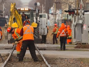 A CP Rail crew replaces worn ties near the Pall Mall and Waterloo Street rail crossings in London, Ont., in this December 8, 2014 file photo. (Mike Hensen/QMI Agency)