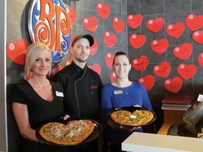 Tillsonburg Boston Pizza's Ashley Sullivan (Bartender), Brian Rocco (Kitchen Manager), and Carol Bangaru (FOH Manager),   serve up a sample of special Valentine's Day heart-shape pizzas that will be available exclusively at Boston Pizza on Saturday, Feb. 14. A portion of the proceeds from the heart-shaped pizzas will be donated to charities supporting youth. (CHRIS ABBOTT/TILLSONBURG NEWS)