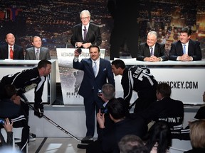 Gavin Maloof drops a puck between two models wearing hockey gear during a news conference at the MGM Grand Hotel & Casino announcing the launch of a season ticket drive to try to gauge if there is enough interest in Las Vegas to support an NHL team on February 10, 2015. (Ethan Miller/Getty Images/AFP)