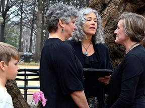 A protester waving a Bible walks past in the background as two women named Donna and Tina get married in a park outside the Jefferson County Courthouse in Birmingham, Alabama. (REUTERS/Marvin Gentry)