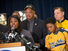 Civil rights leader Rev. Jesse Jackson (C) looks on as Brandon Green (front right), a catcher and pitcher for the Jackie Robinson West Little League baseball team, listens as his mother Venisa speaks at a press conference on February 11, 2015 in Chicago, Illinois. (Scott Olson/Getty Images/AFP)